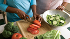 Mujer rebanando verduras en una tabla de picar Mujer rebanando verduras en una tabla de picar
