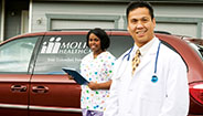 Doctor and nurse standing next to Molina Healthcare van