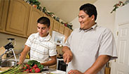 father and son cutting vegetables father and son cutting vegetables