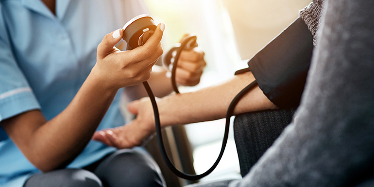 Provider checking patient's blood pressure