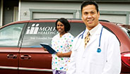Doctor and nurse standing in front of a Molina van