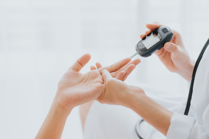 doctor using a glucometer on patient