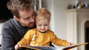 man reading to son