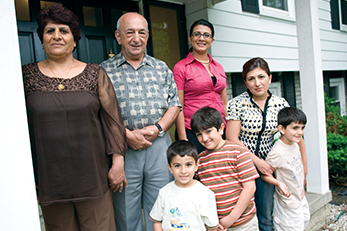 multi-generational family standing in front of house