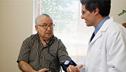 Médico midiendo la presión arterial de un hombre