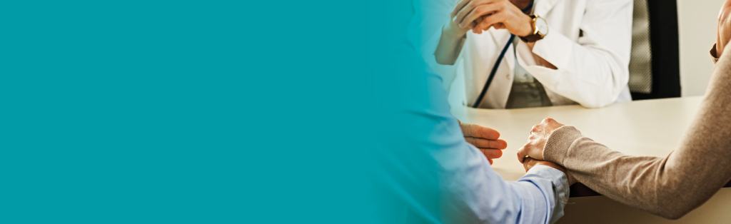 personas tomadas de la mano y hablando con el médico