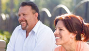 Pareja sonriendo sentada afuera Pareja sonriendo sentada afuera