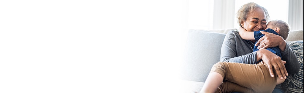 Woman hugging child on lap while smiling