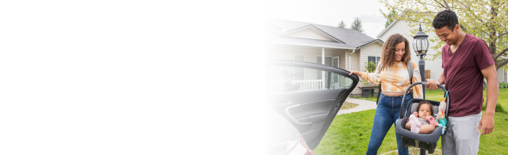A man and a woman with a baby in carseat entering car