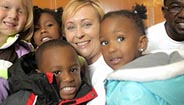 Woman surrounded by group of children Woman surrounded by group of children