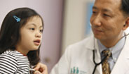 Médico revisando la frecuencia cardiaca de unos niños Médico revisando la frecuencia cardiaca de unos niños