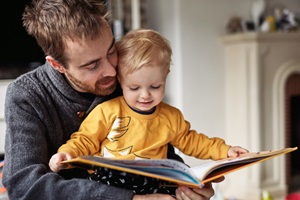 man and boy reading book