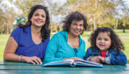 Family sitting at table outside Family sitting at table outside
