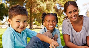 woman and two children smiling woman and two children smiling