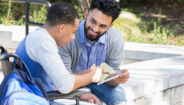 two men sitting outside looking at tablet two men sitting outside looking at tablet