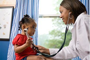 doctora revisando el corazón de una niña con estetoscopio
